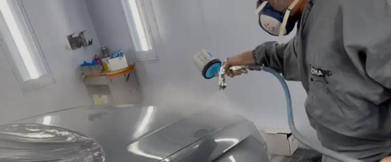 Mise en peinture d'un véhicule dans la cabine de l'atelier